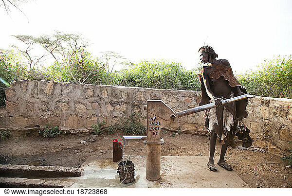 An older woman pumps water from a well in the rural Hamer village of southern Ethiopia.