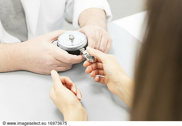 an orthopedist assesses the strength of the fingers of one hand