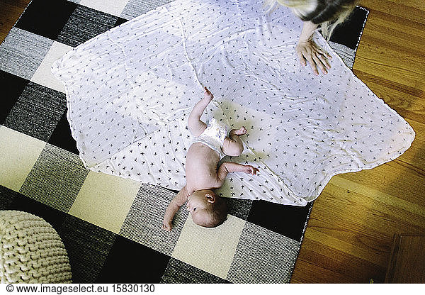 An overhead view of a newborn baby boy laying on a blanket