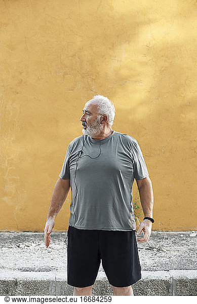 An overweight older man is ready to stretch