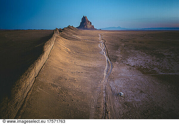 An RV is parked near Shiprock mountain  New Mexico