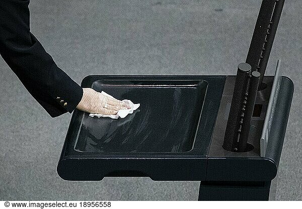 An usher disinfects the lectern during the special event in the German Bundestag to mark the 75th anniversary of the United Nations. Berlin  18.12.2020.  Berlin  Germany  Europe