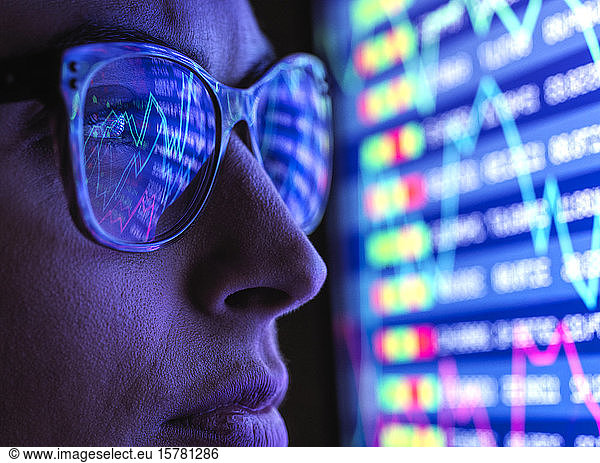 Analystin  die Finanzmarktdaten auf einem Bildschirm betrachtet