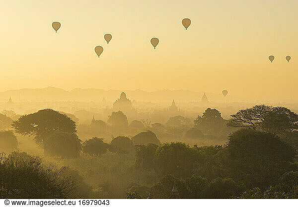 Ancient temples and hot air balloons at misty sunrise  Bagan  Ma