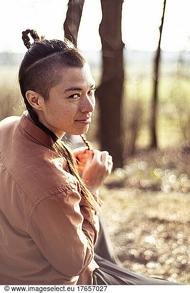 androgynous mixed race woman with freckles plats hair outside