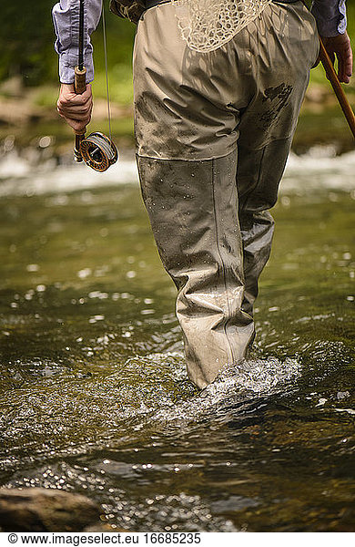 Angler walking through the river