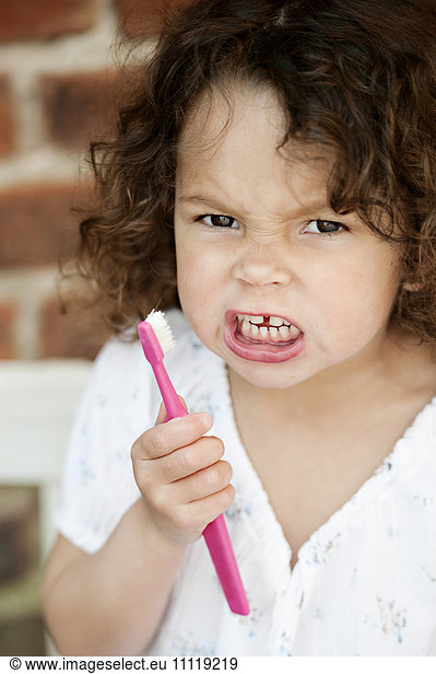 Angry girl holding toothbrush