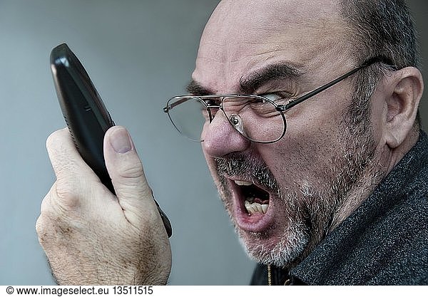 Angry man shouting into a telephone receiver
