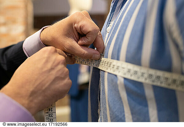 Anonymous dressmaker making customer measurements