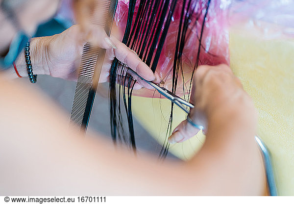 Anonymous hairdresser's hands cutting hair