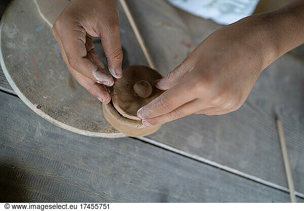 Anonymous kid creating clay pot