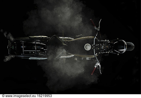 Ansicht eines Oldtimer-Motorrads von oben mit Rauch und schwarzem Hintergrund (Ardie RZ 200 Peter)