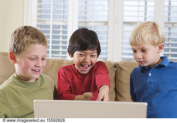 Ansichten von drei Freunden  die auf einen Laptop schauen.