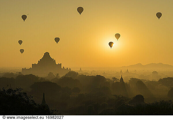 Antike Tempel und Heißluftballons bei nebligem Sonnenaufgang  Bagan  Ma