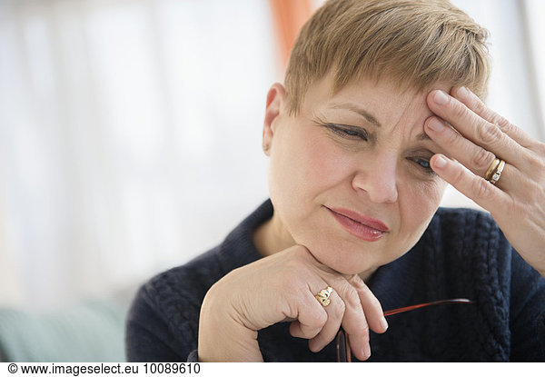 Anxious Caucasian woman rubbing forehead