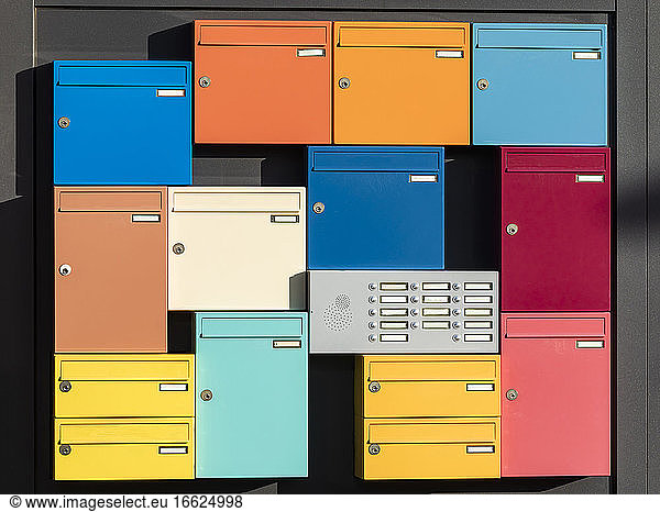 Apartment intercom surrounded by colorful mailboxes