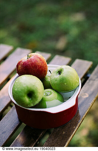Apples in a bowl with water.