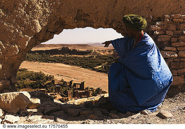 Arab guide pointing out the kasbah of Ait Ben Haddou