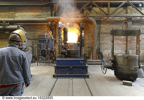 Arbeiter  der die Temperatur des Materials in einer Gießerei überprüft