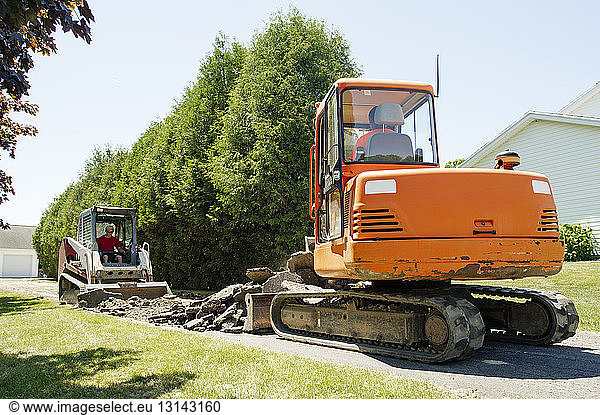 Arbeiter graben Land  während sie in einer Erdbewegungsmaschine sitzen
