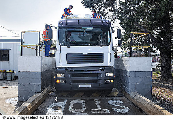 Arbeiter in reflektierenden Westen beladen Lastwagen