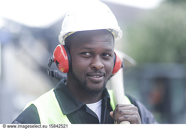 Arbeiter jung männlich mit Helm außen mit Schaufel