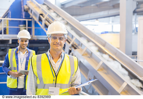 Arbeiter lächeln im Recyclingzentrum