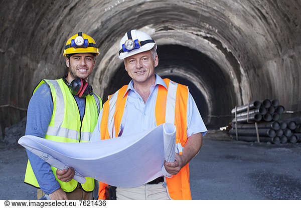 Arbeiter lesen Blaupausen im Tunnel