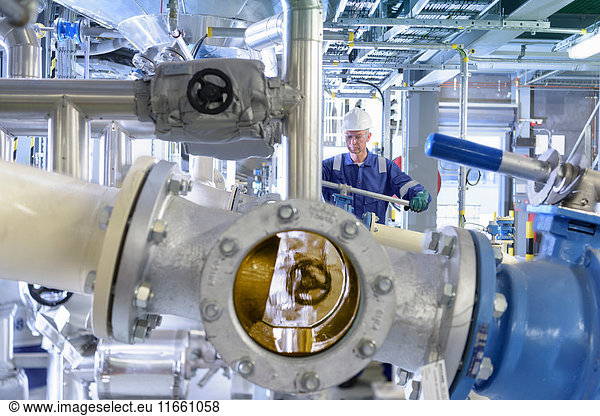 Arbeiter mit Prozessmaschinen in einer Ölmischfabrik