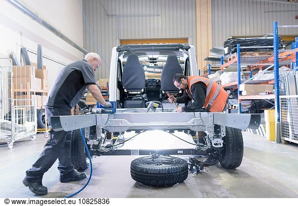 Arbeiter montieren Fahrgestelle an Reisemobil-Produktionslinie
