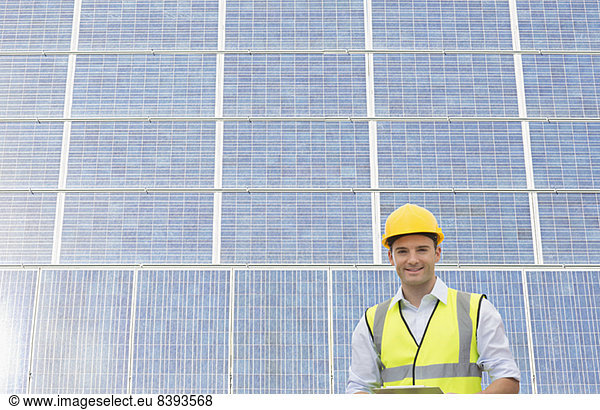 Arbeiter steht im Schatten der Windkraftanlage