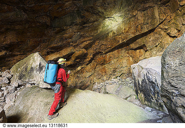 Archäologe in voller Länge in Höhle stehend