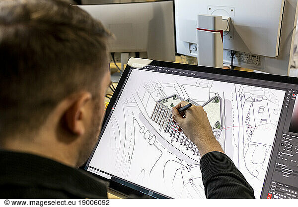 Architect drawing on graphics tablet in office