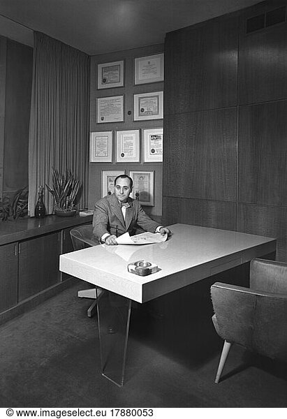 Architect Morris Lapidus  portrait sitting at his office desk  New York City  New York  USA  Gottscho-Schleisner Collection  December 1946