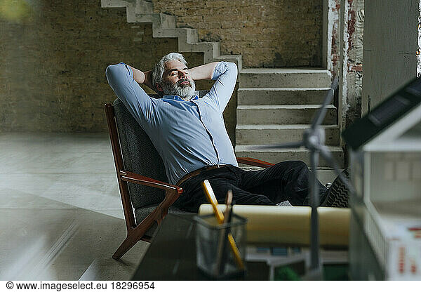 Architect relaxing in chair at under construction site