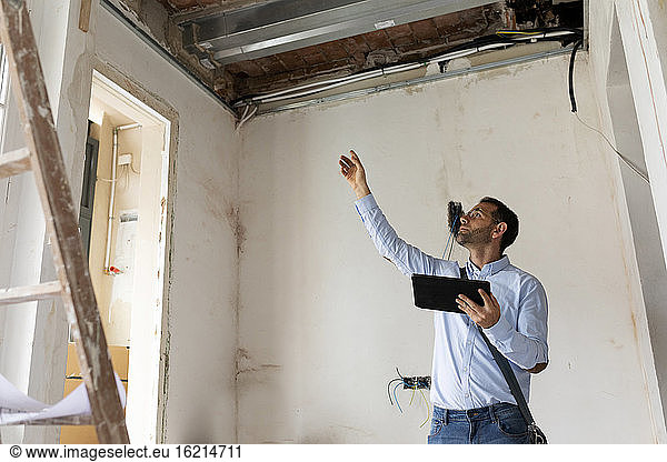 Architect using tablet in a house under construction