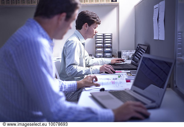 Architects working at laptops at desk