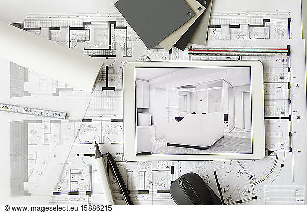 Architectural blueprints and digital tablet displaying modern showcase interior