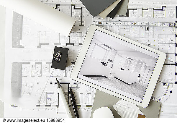 Architectural blueprints and digital tablet displaying modern showcase interior