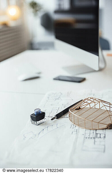 Architectural model and blueprint on desk in office