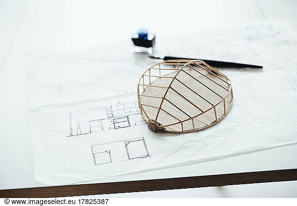 Architectural model over blueprint on desk in office