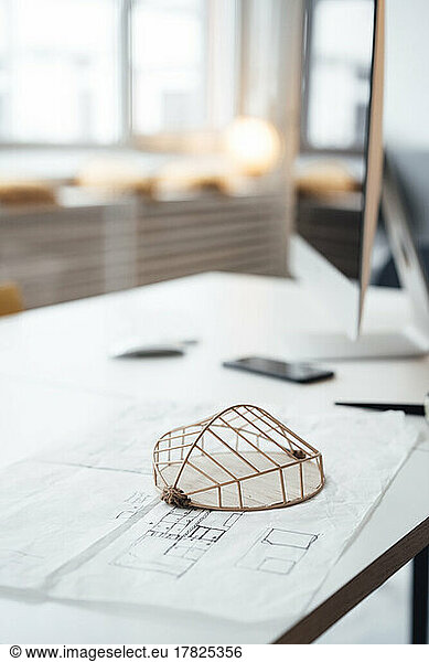 Architectural model with blueprint on desk in office