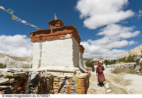 architecture Buddhism Buddhist building Chhoser chorten daytime man Mani stones mani wall Nepal one person outdoors person religion religious travel photography Upper Mustang wall wall