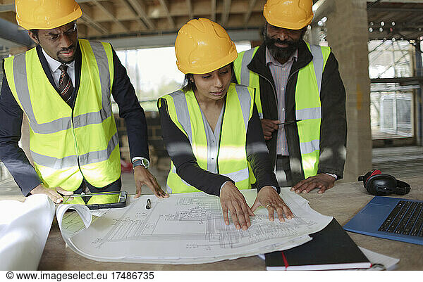 Architekten besprechen Baupläne auf der Baustelle