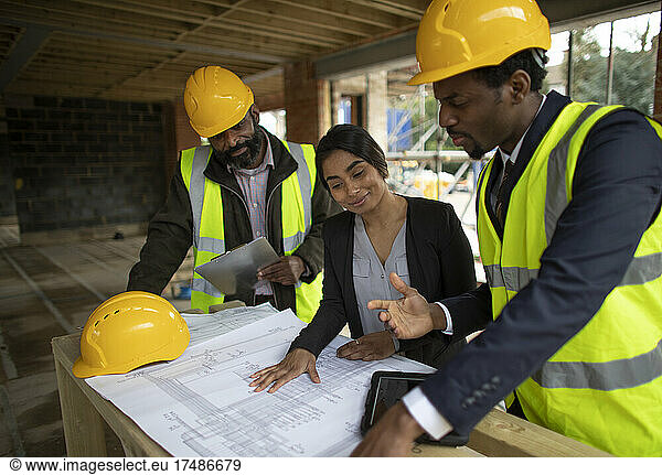 Architekten und Ingenieure besprechen Baupläne auf der Baustelle