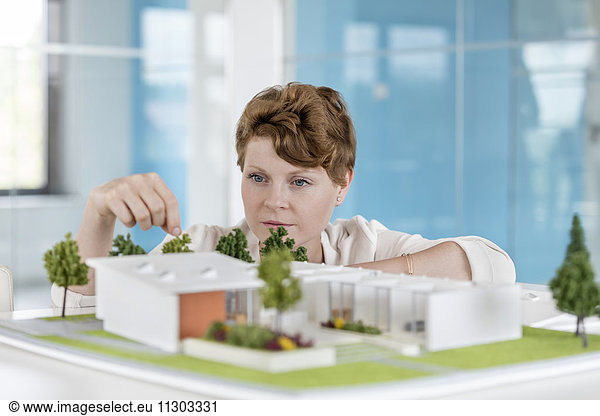 Architektin arrangiert Gebäudemodell im Büro