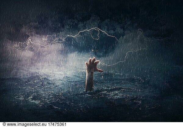 Arm drowning in the sea. Surreal and dramatic scene of person hand sinking in the ocean under a hurricane stormy weather. People need help in risk situations. Despair  depression and failure metaphor