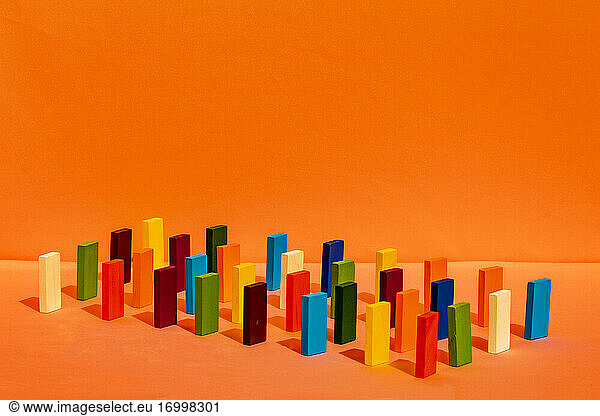 Arrangement of colorful toy blocks in a row on orange background
