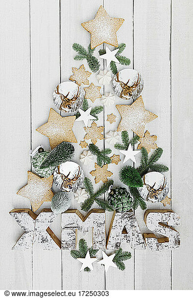 Arrangement of homemade cookies and various Christmas decorations hanging on wooden wall