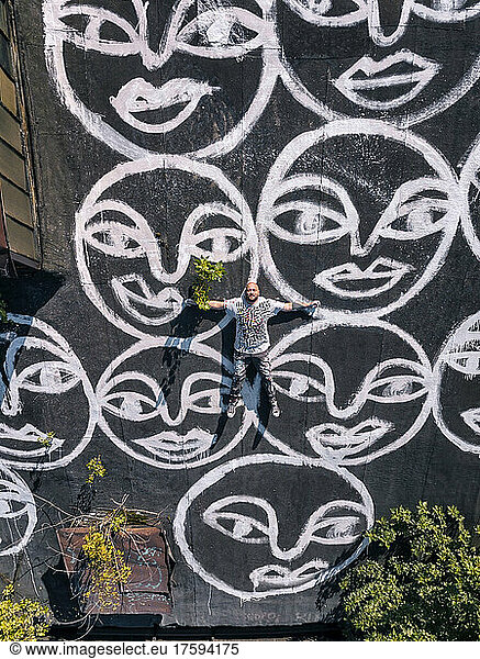 Artist lying down on graffiti on roof